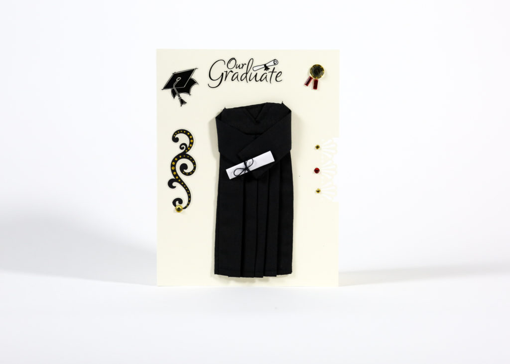 Image of white card with "Our graduate" top center, with graduation robe and diploma, graduation cap, ribbon, and gemstone designed. 
